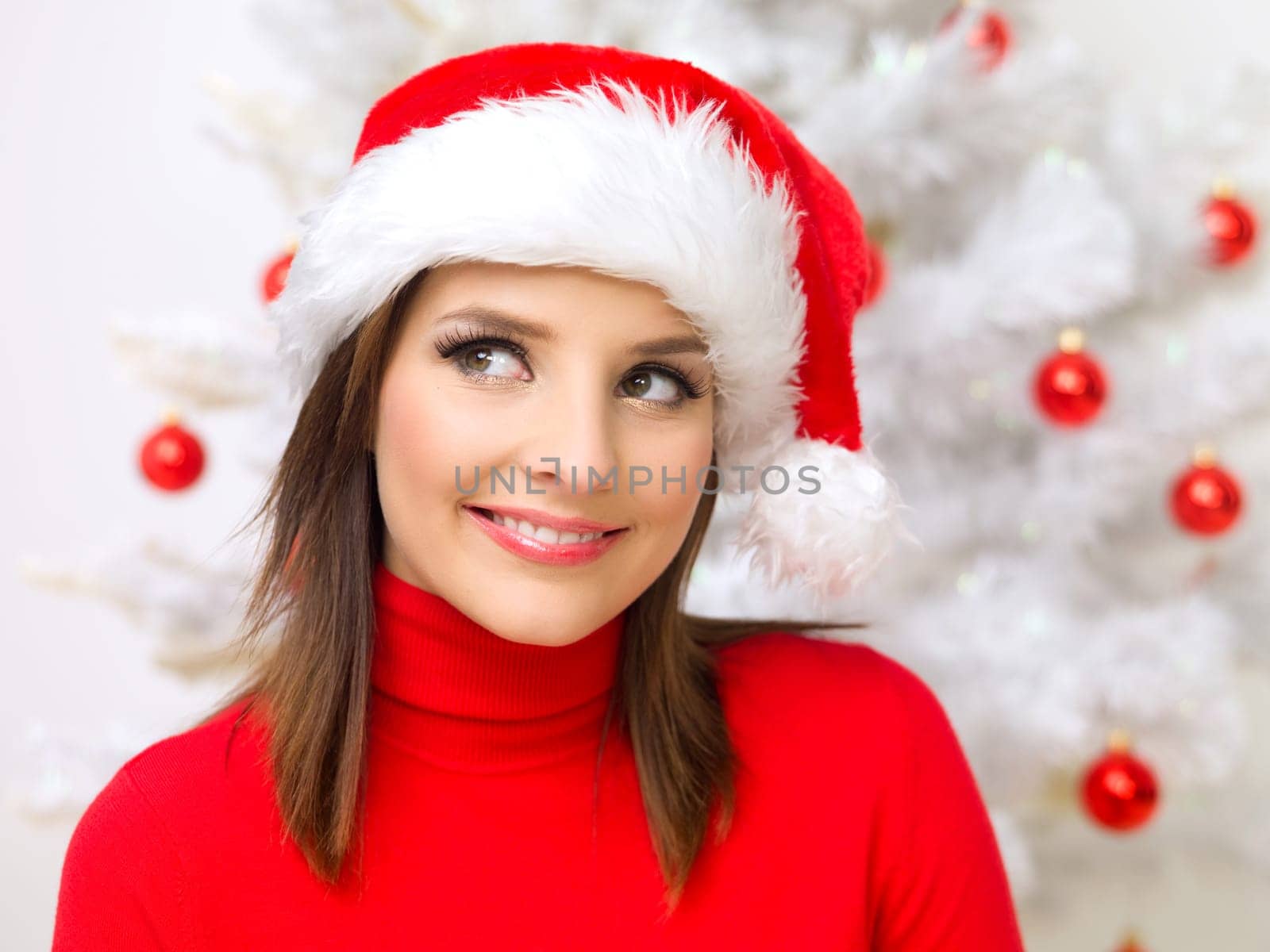 Beautiful woman next to christmas tree wearing red sweater