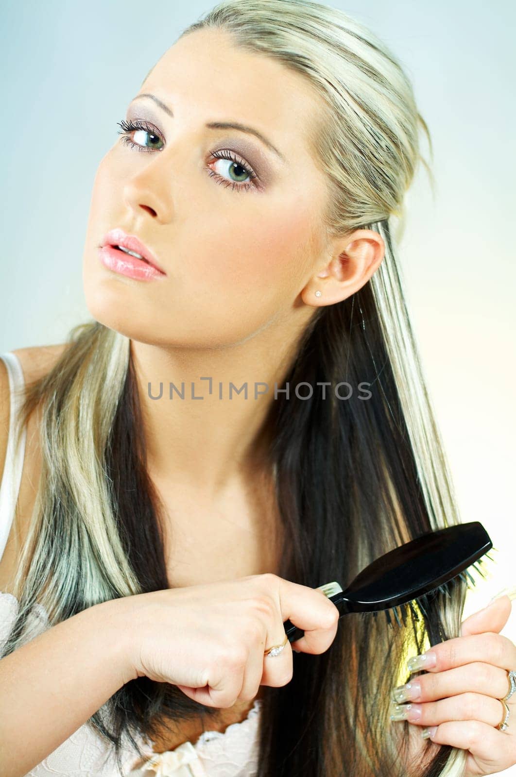 Sexy blonde young woman brushing hair