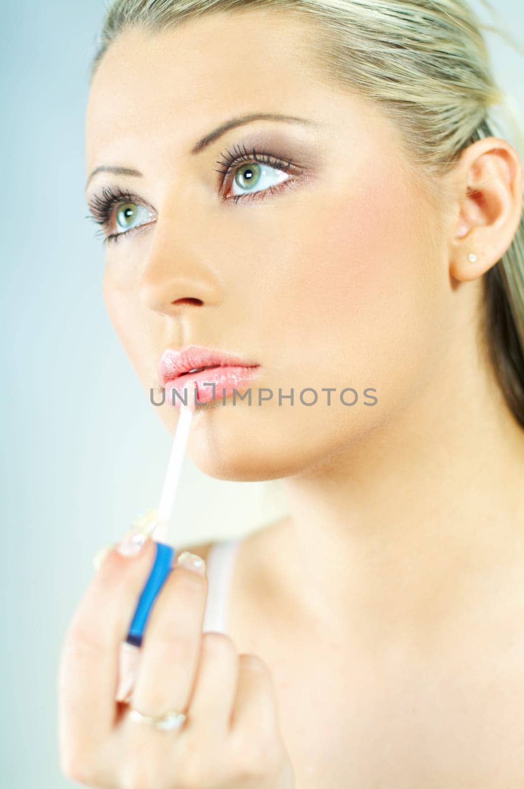 Portrait of blonde young sexy woman doing makeup