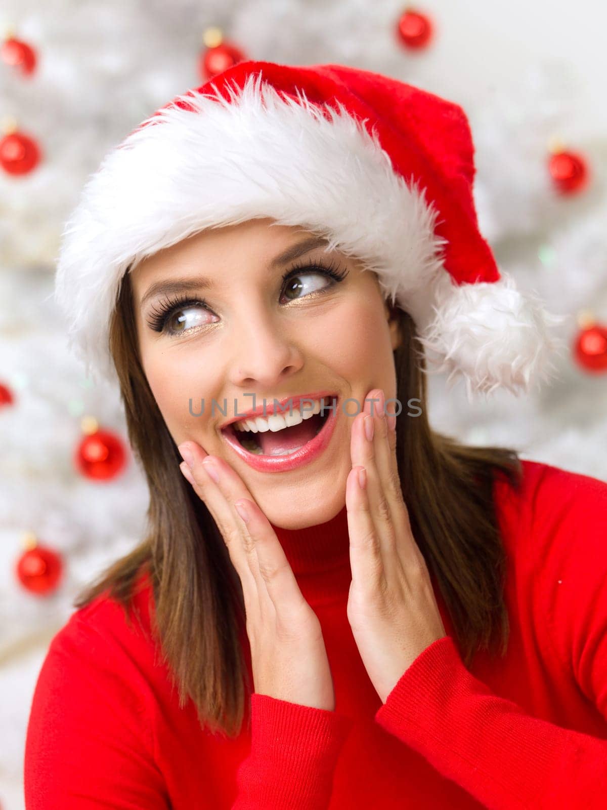Beautiful woman next to christmas tree wearing red sweater