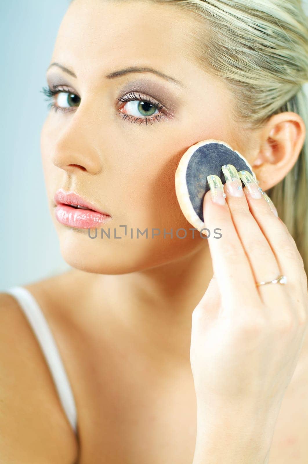 Portrait of blonde young sexy woman doing makeup