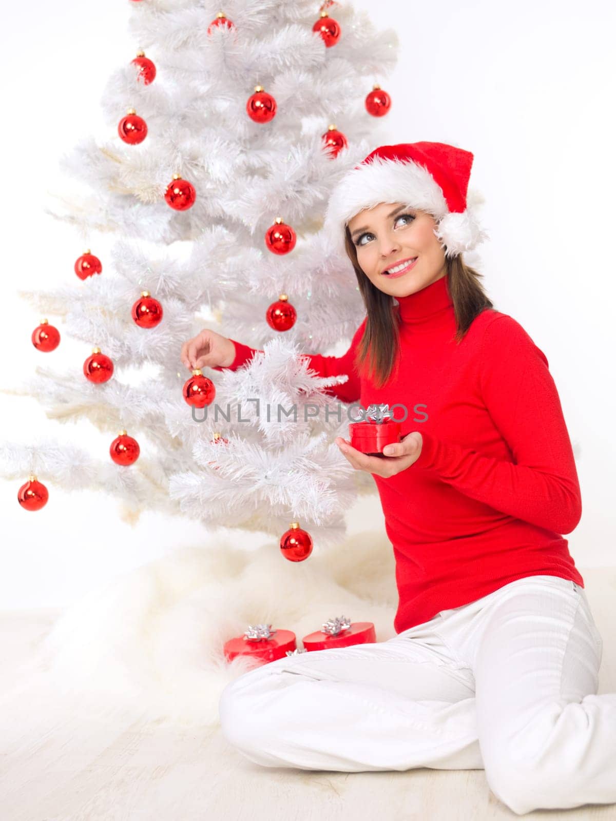 Beautiful woman next to christmas tree wearing red sweater