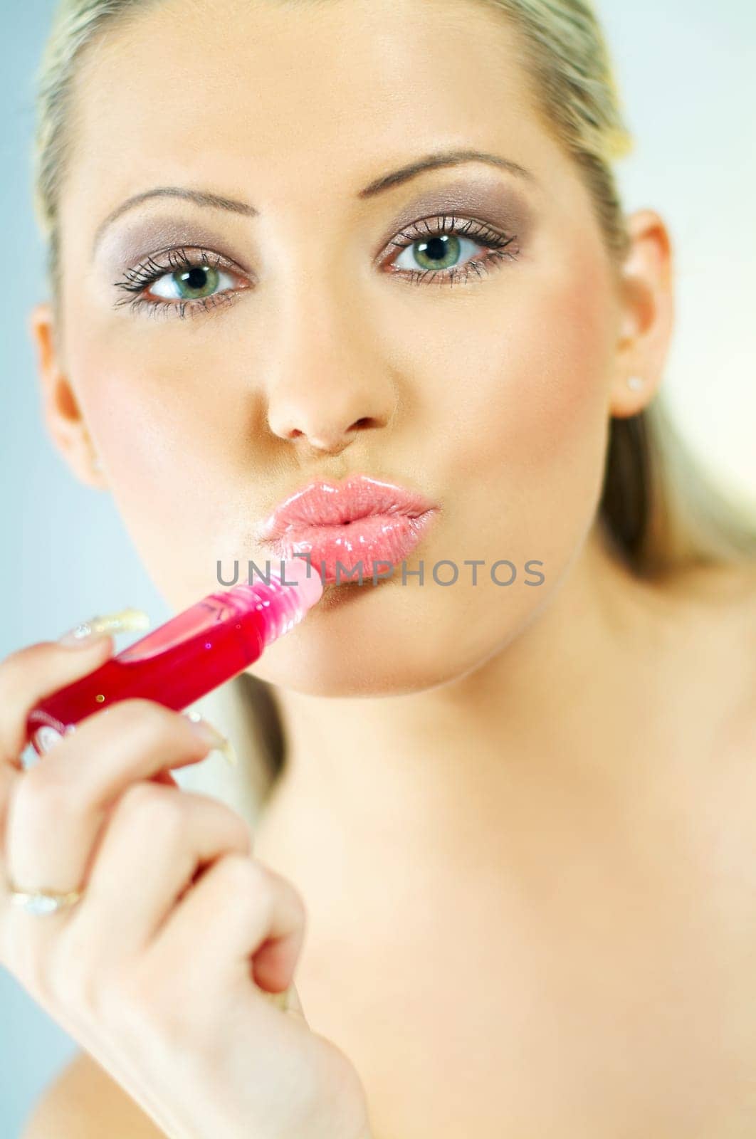 Portrait of blonde young sexy woman doing makeup