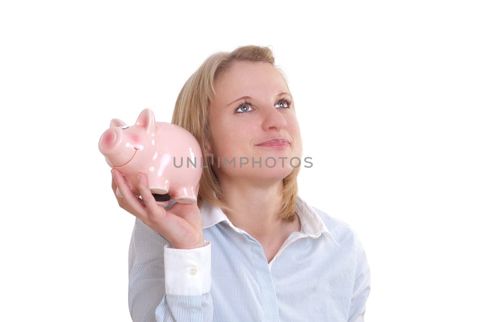 Young blonde woman holding a piggy bank and pondering
