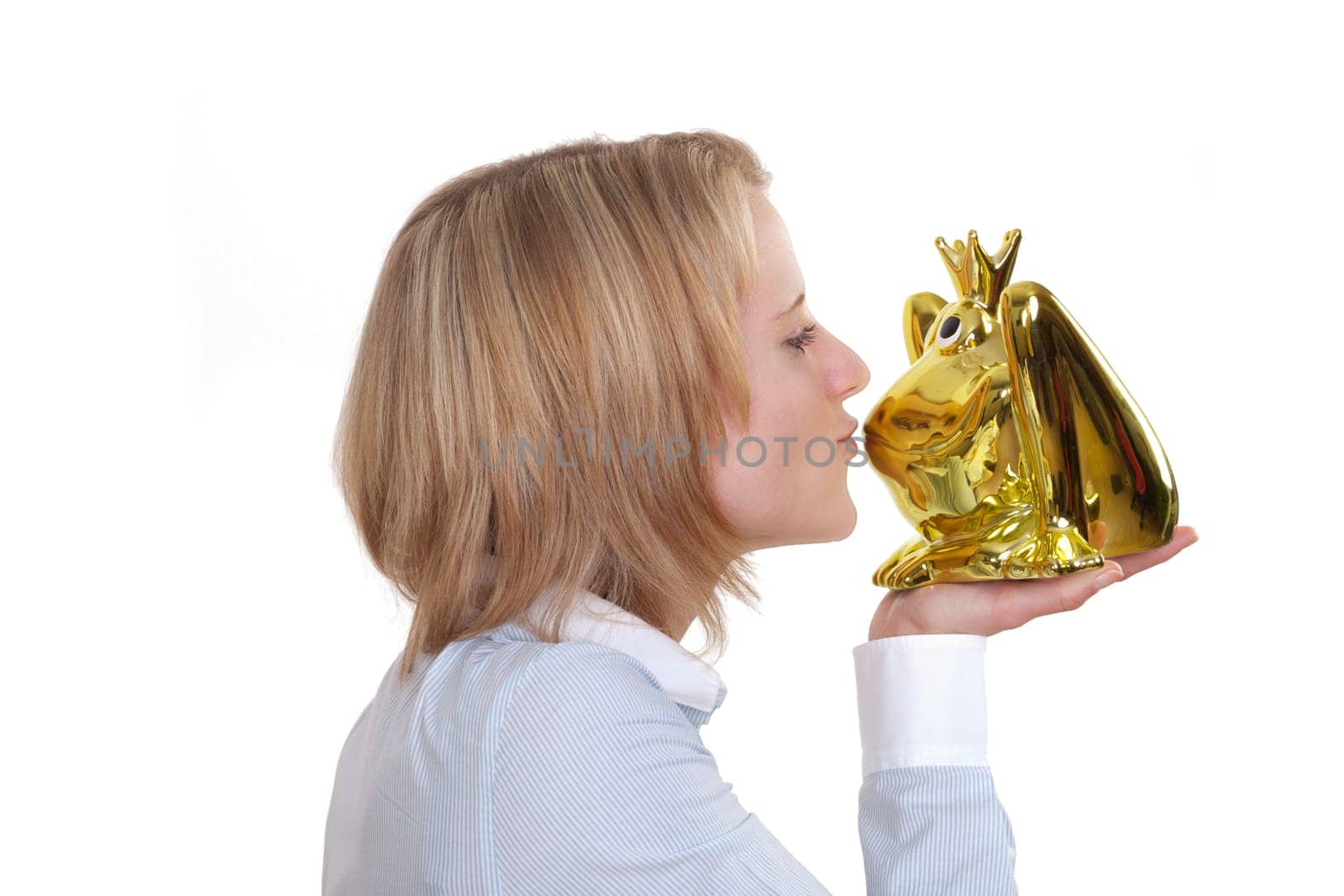 Young blonde woman holding a golden frog in her hand and wants to kiss them