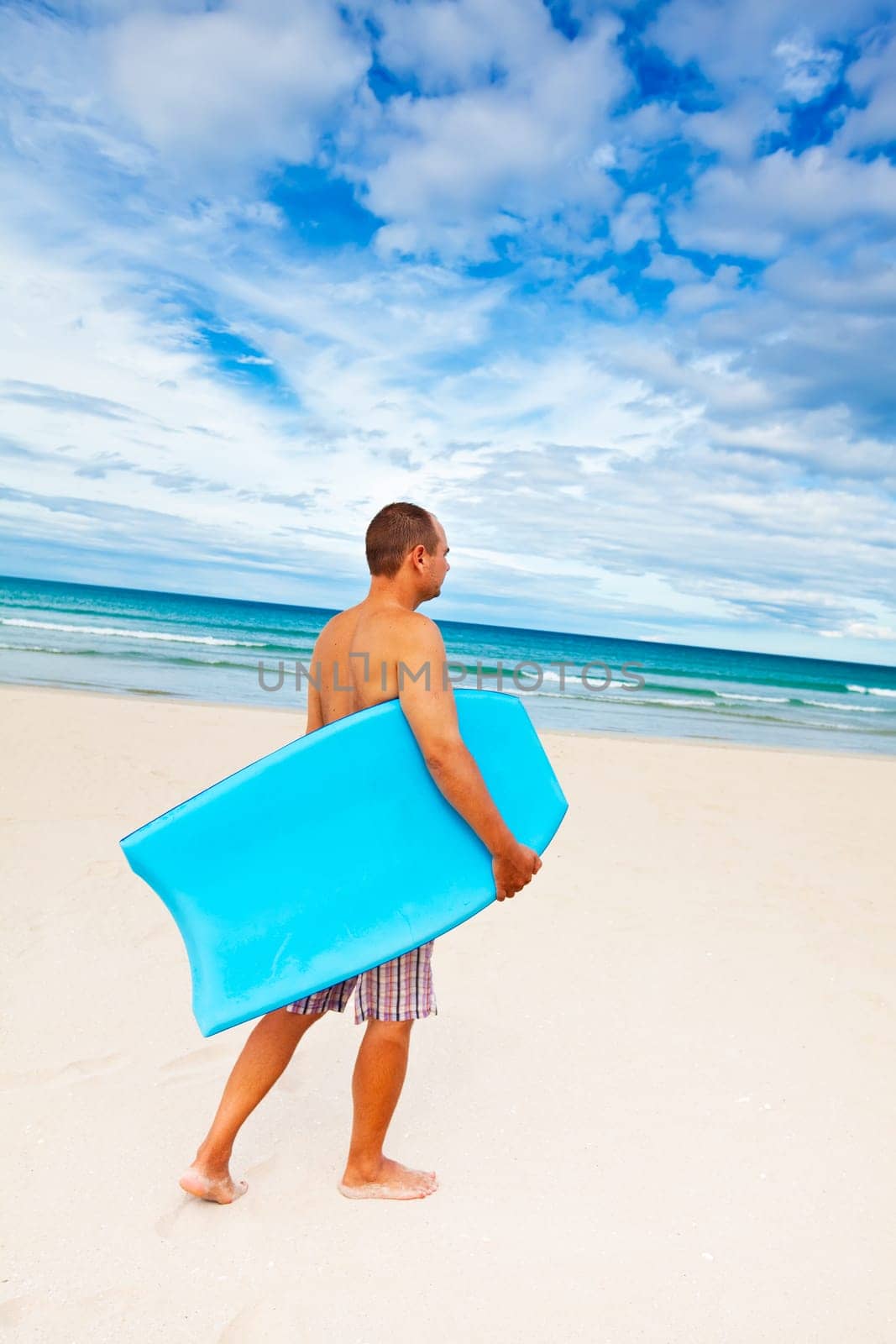 Man with body board on the tropical beach