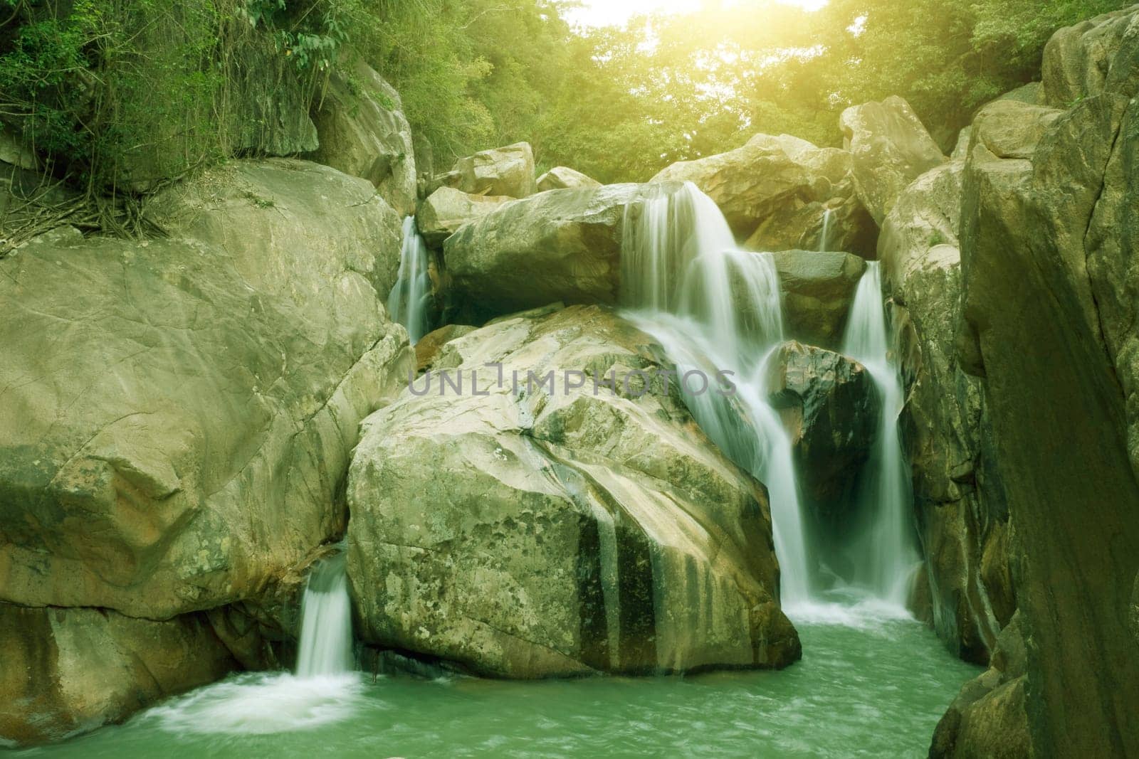 Waterfall pool in rain forest and sunlight