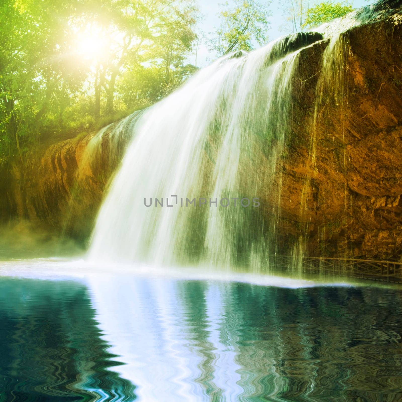 Waterfall pool in rain forest and sunlight