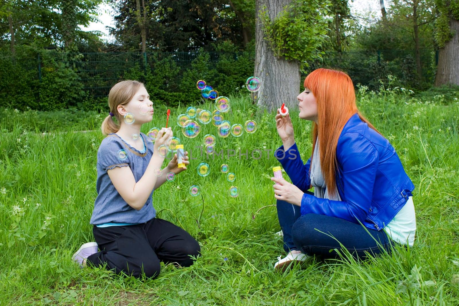 Little girl and young woman blowing soap bubbles