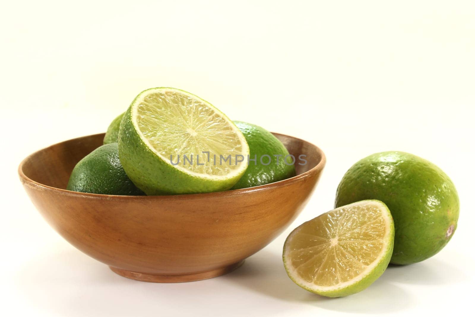 fresh limes in a wooden bowl