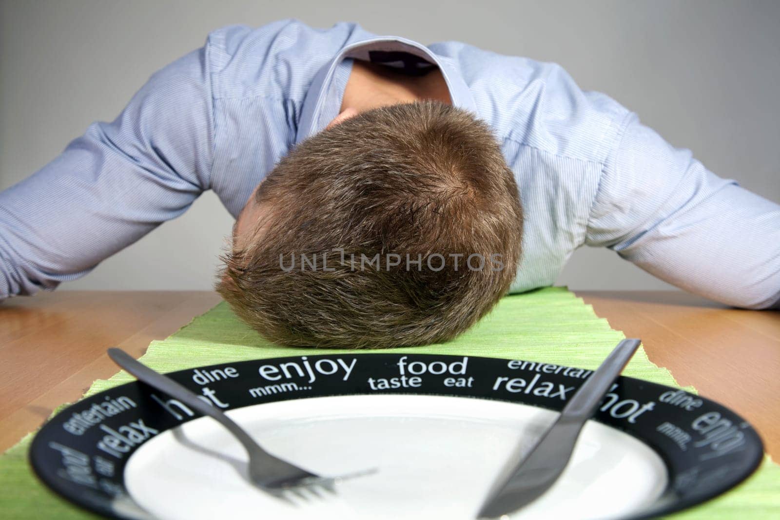 Man falls asleep on a table after eating