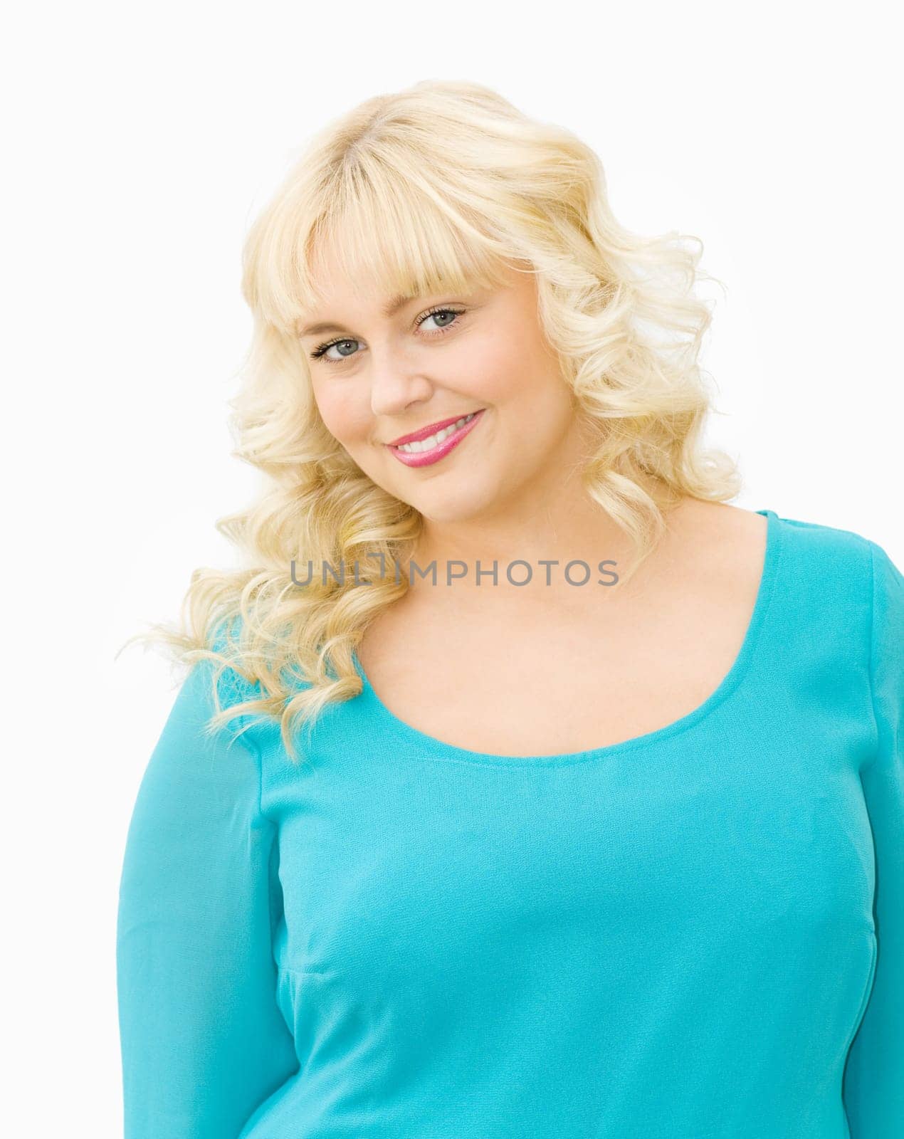 Portrait of beautiful young woman with blonde hair and blue eyes. Smiling and wearing pretty blue dress.