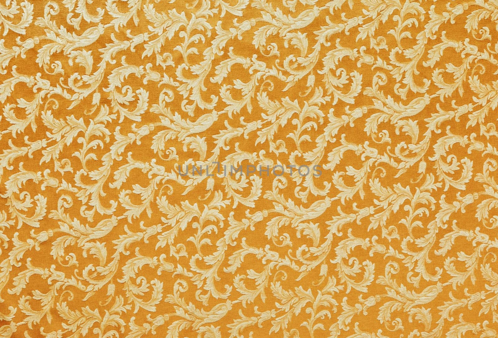Abstract background of a heavy golden brocade fabric with interwoven repeat design.