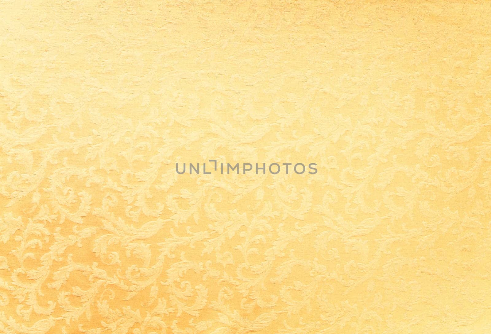 Abstract background of a heavy golden brocade fabric with interwoven repeat design.