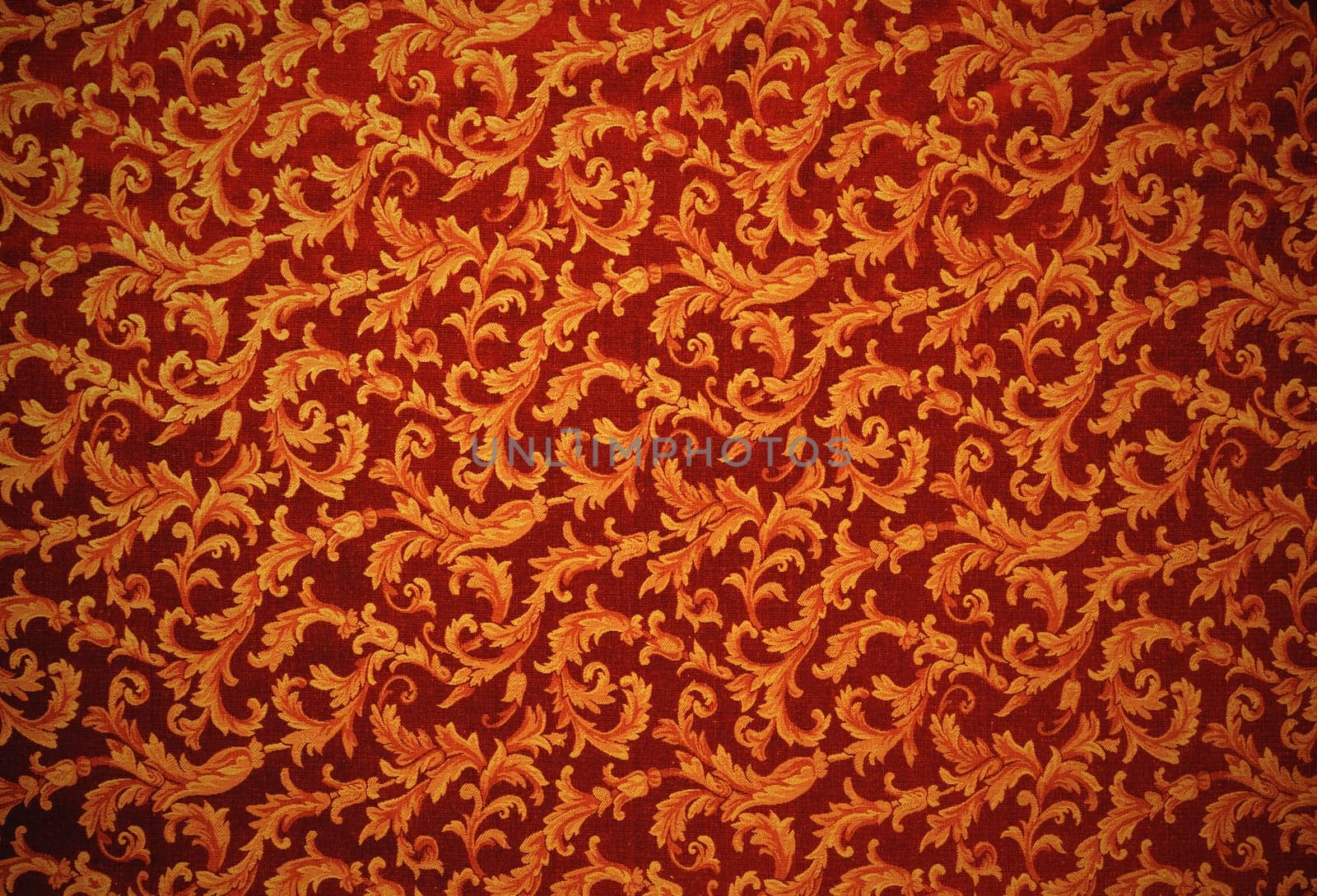 Abstract background of a heavy copper brocade fabric with interwoven repeat design.
