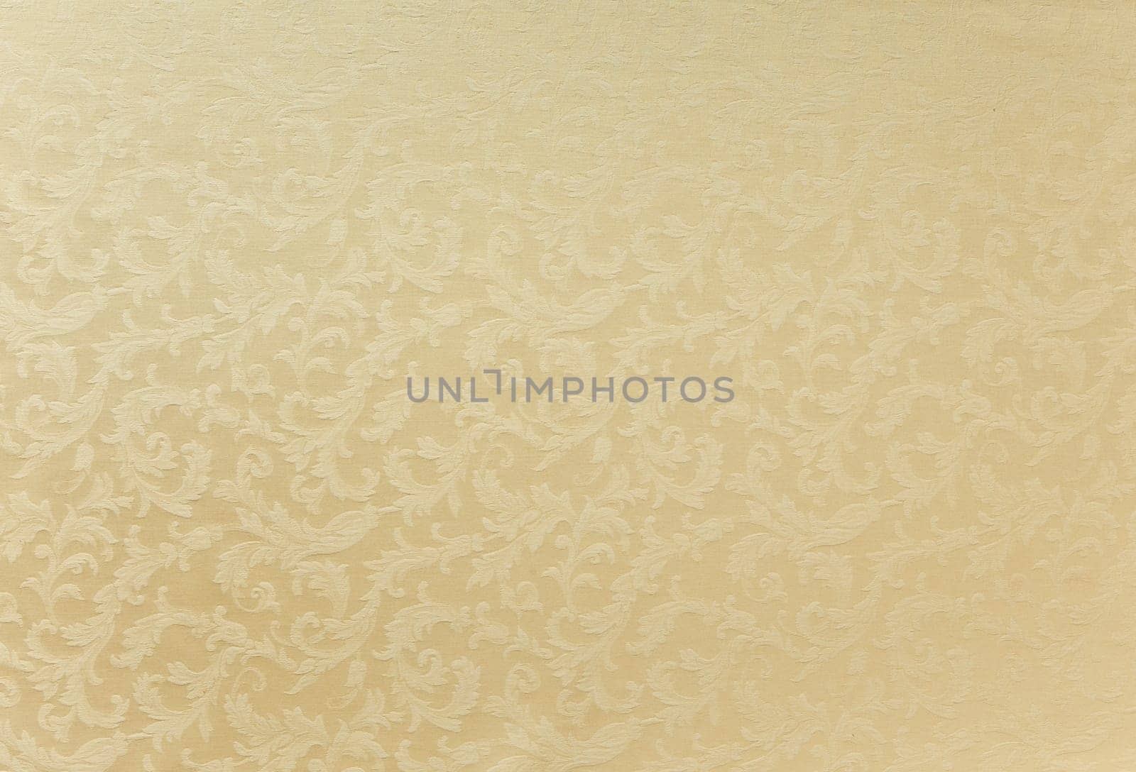 Abstract background of a heavy beige brocade fabric with interwoven repeat design.