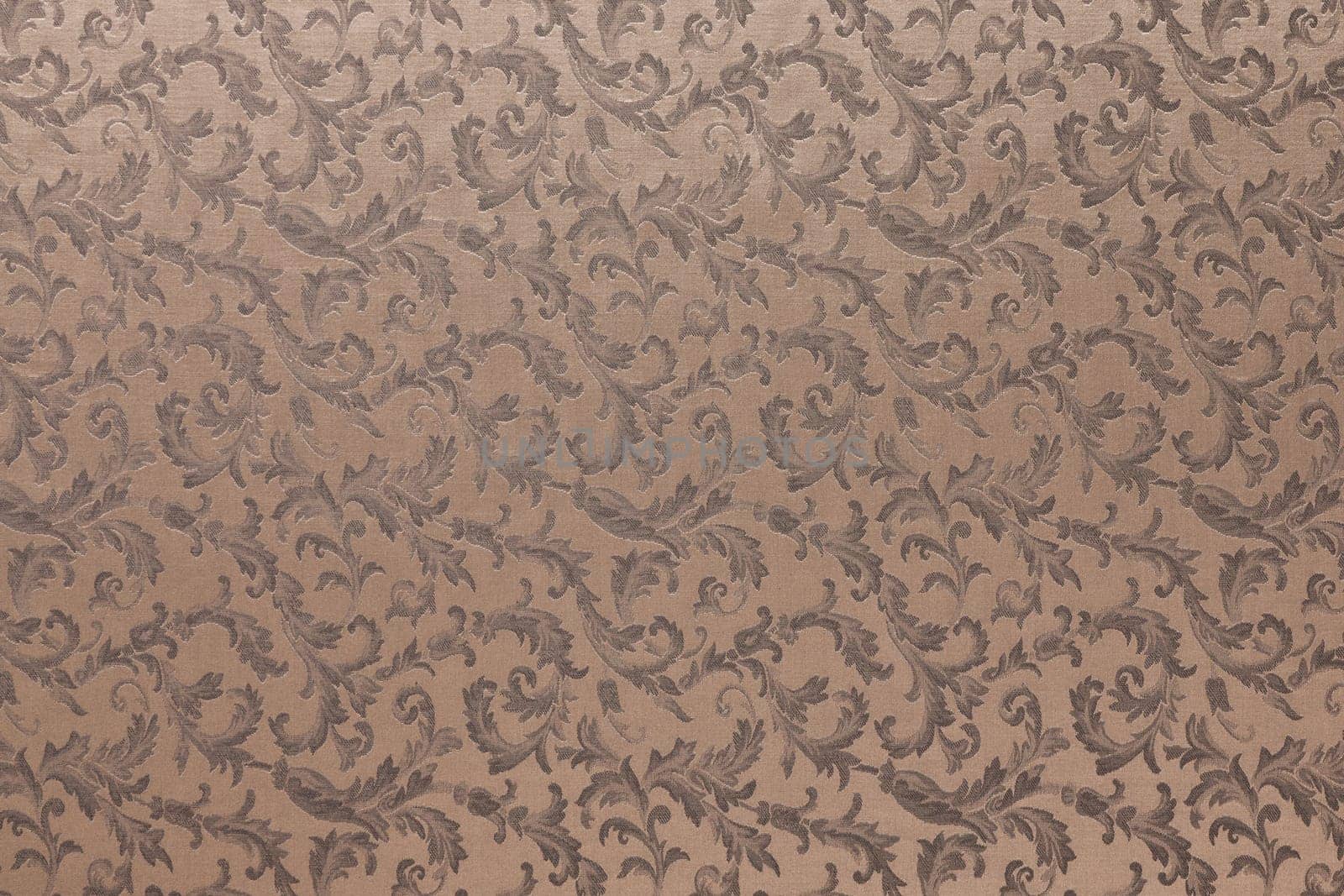 Abstract background of a heavy brown brocade fabric with interwoven repeat design.