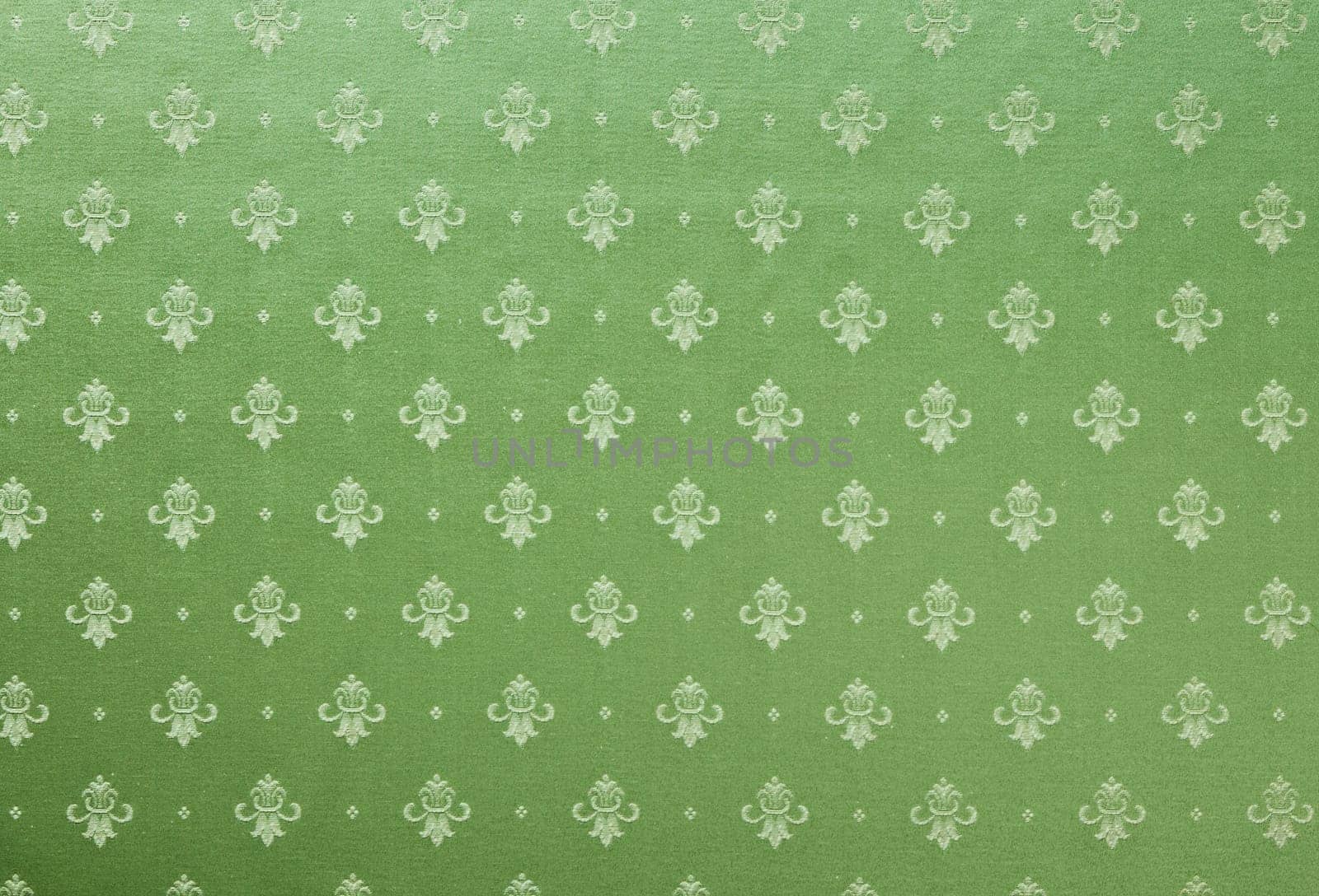 Abstract background of a heavy green brocade fabric with interwoven repeat design.