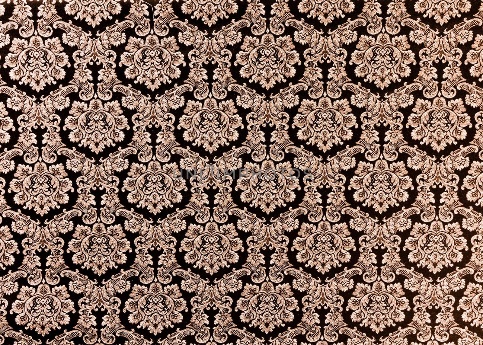 Abstract background of a heavy purple brocade fabric with interwoven repeat design.