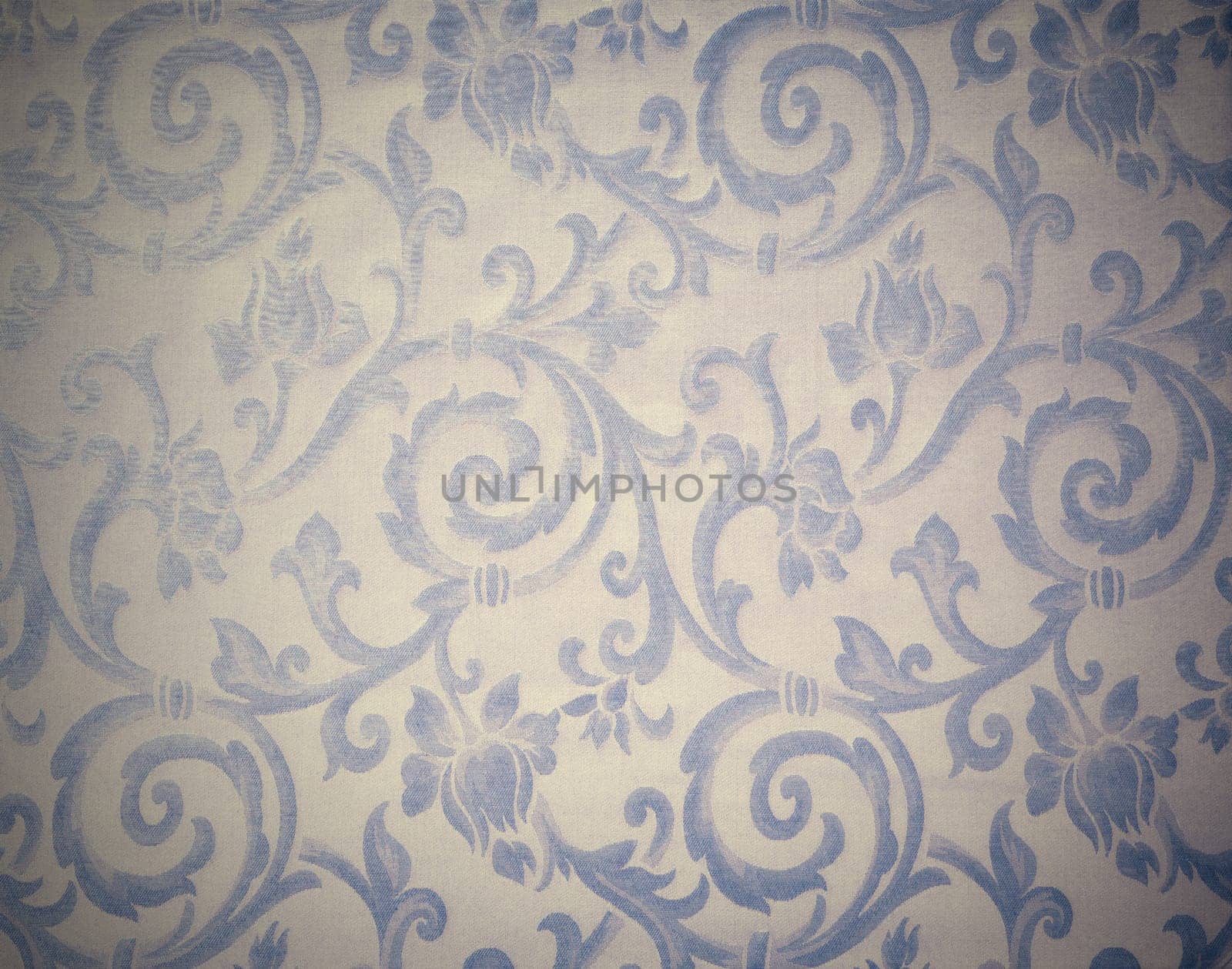 Abstract background of a heavy grey blue brocade fabric with interwoven repeat design.