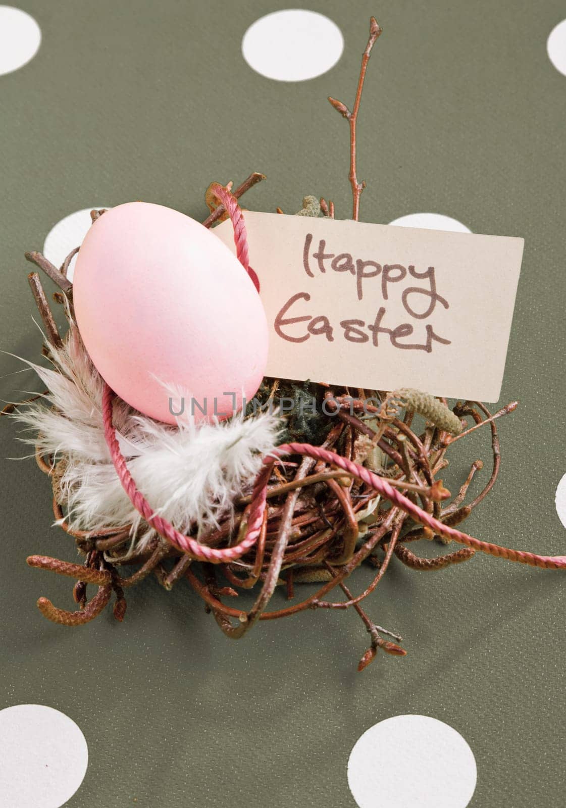 Colored egg in a small nest with a Happy Easter tag