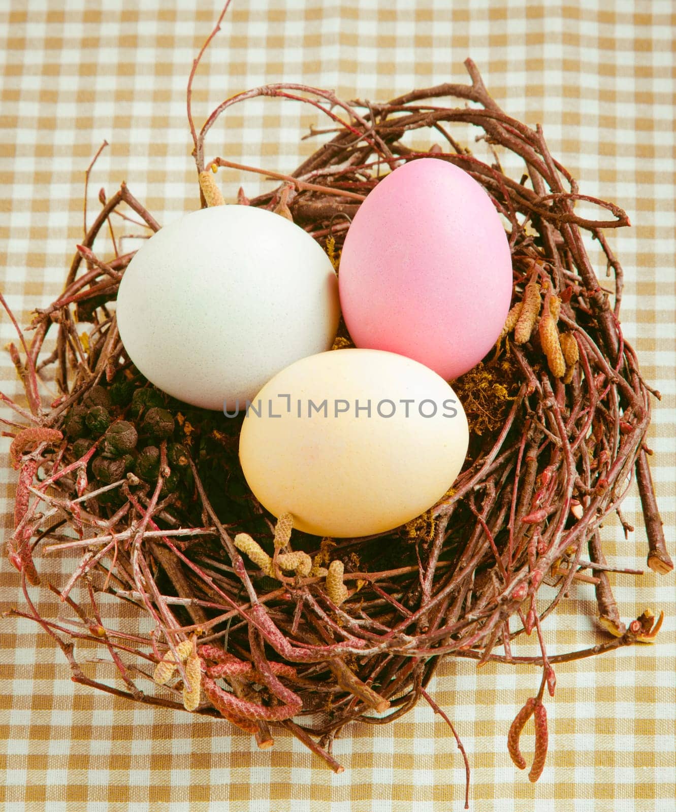 Three boiled dyed Easter Eggs in a nest for happy easter