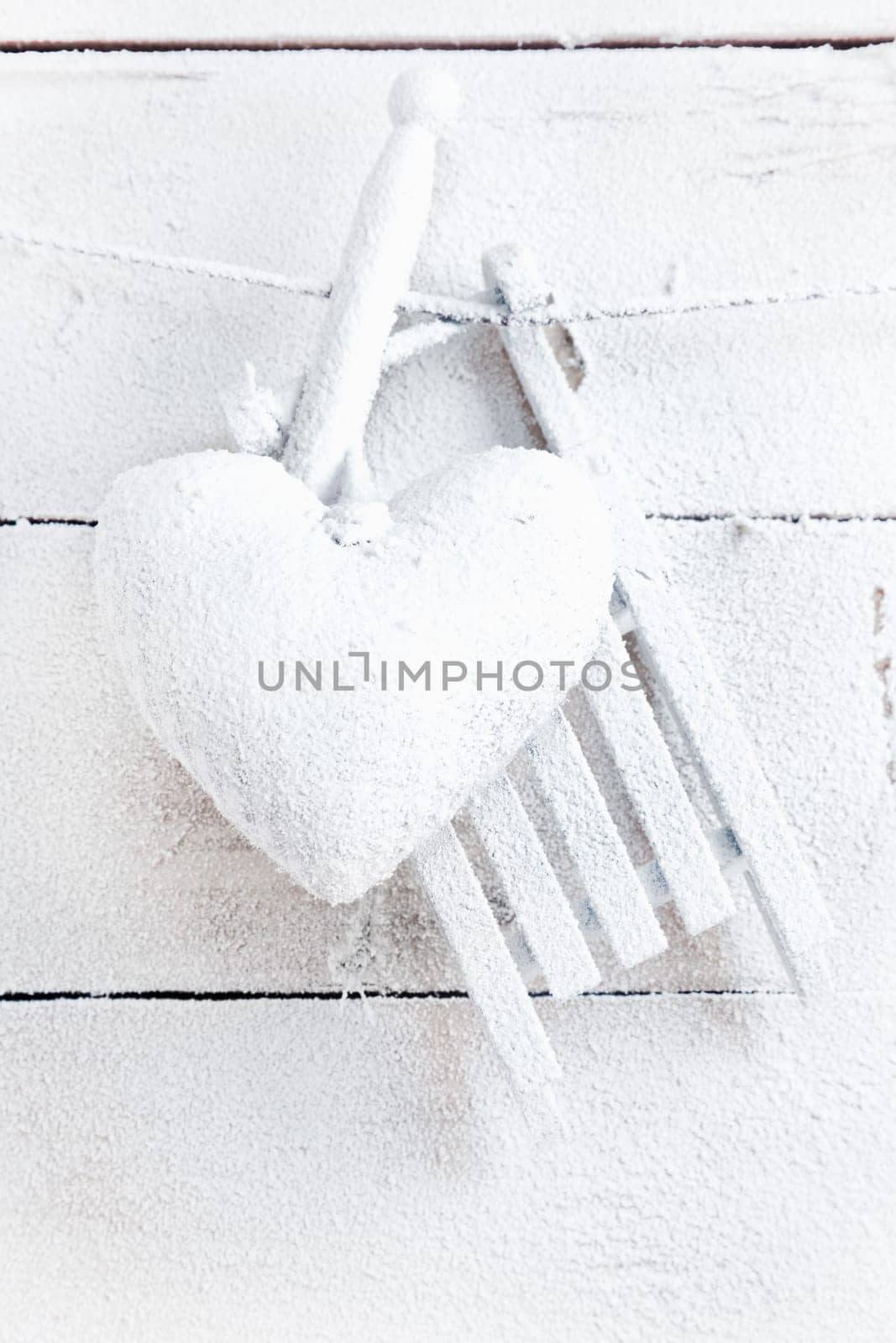 Romantic checked snowy needlework heart for Valentines hanging on snow white boards with copyspace