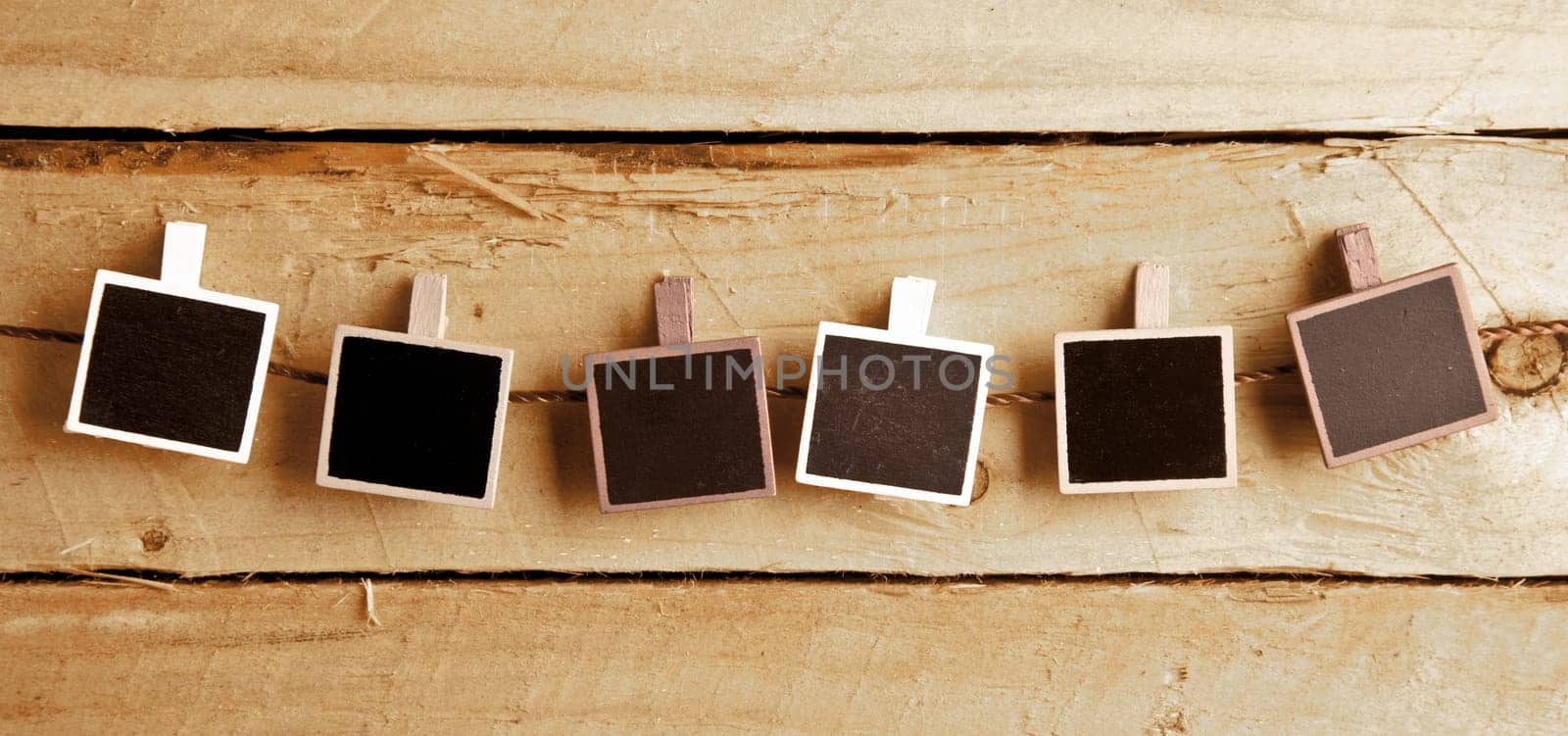 Six Squary Polaroid-style photo frames in a row on a wooden background