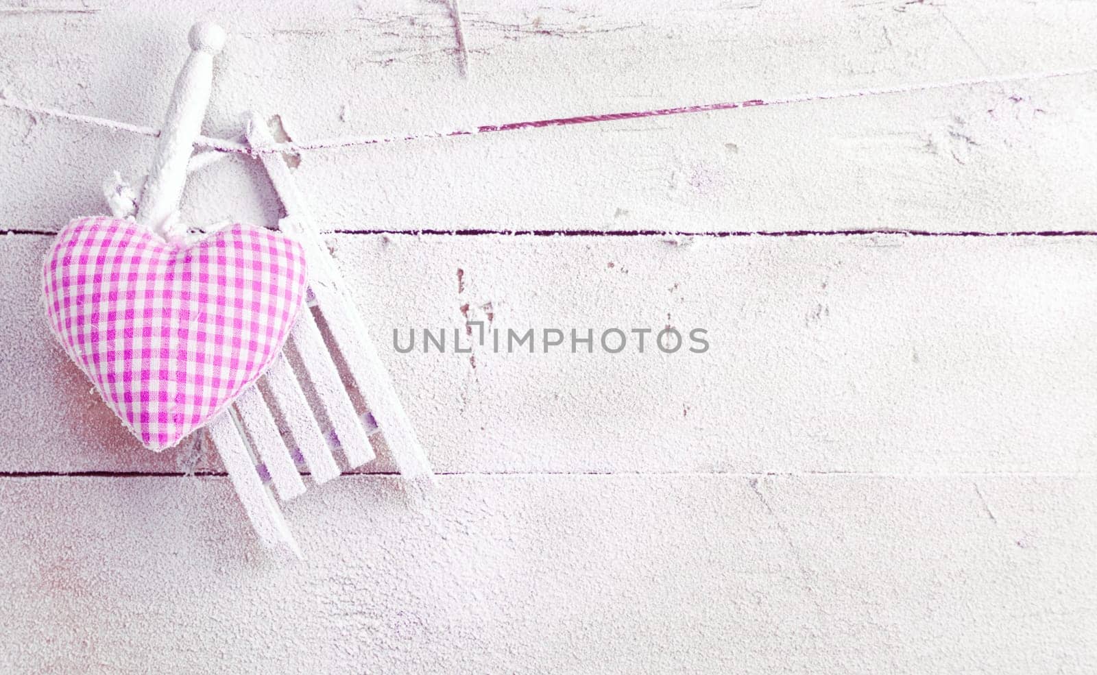Romantic checked violet needlework heart for Valentines hanging on old painted white boards with copyspace