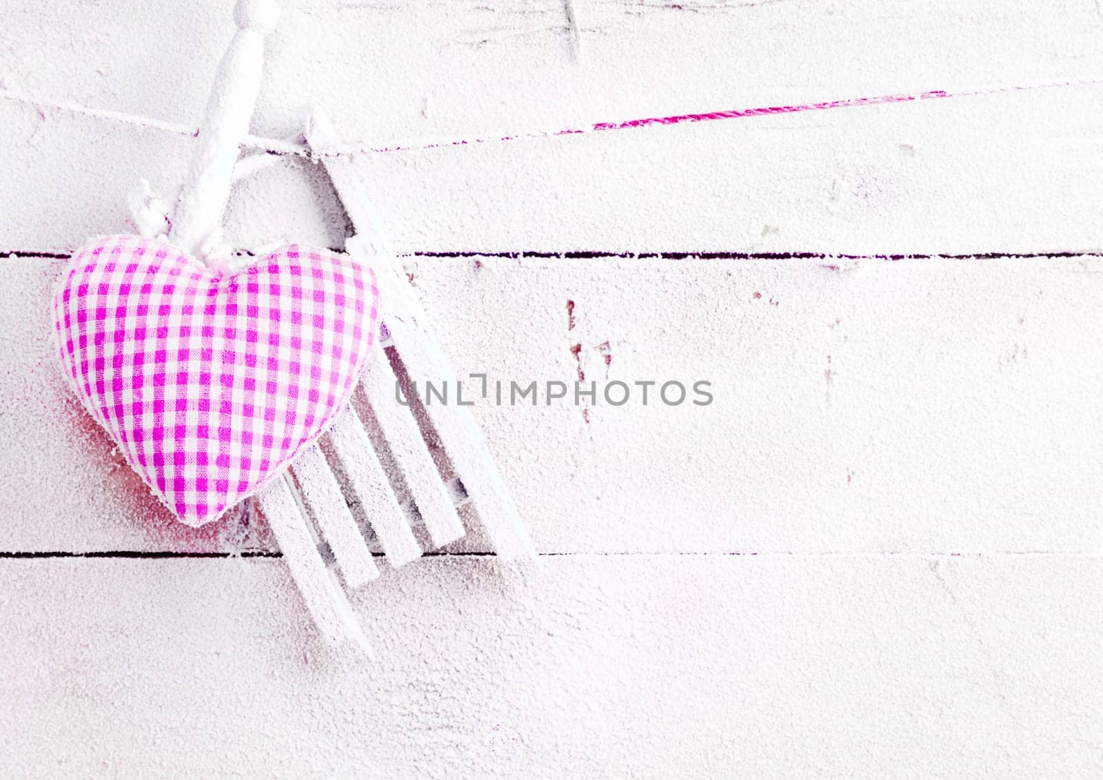Romantic checked snowy needlework heart for Valentines hanging on snow white boards with copyspace