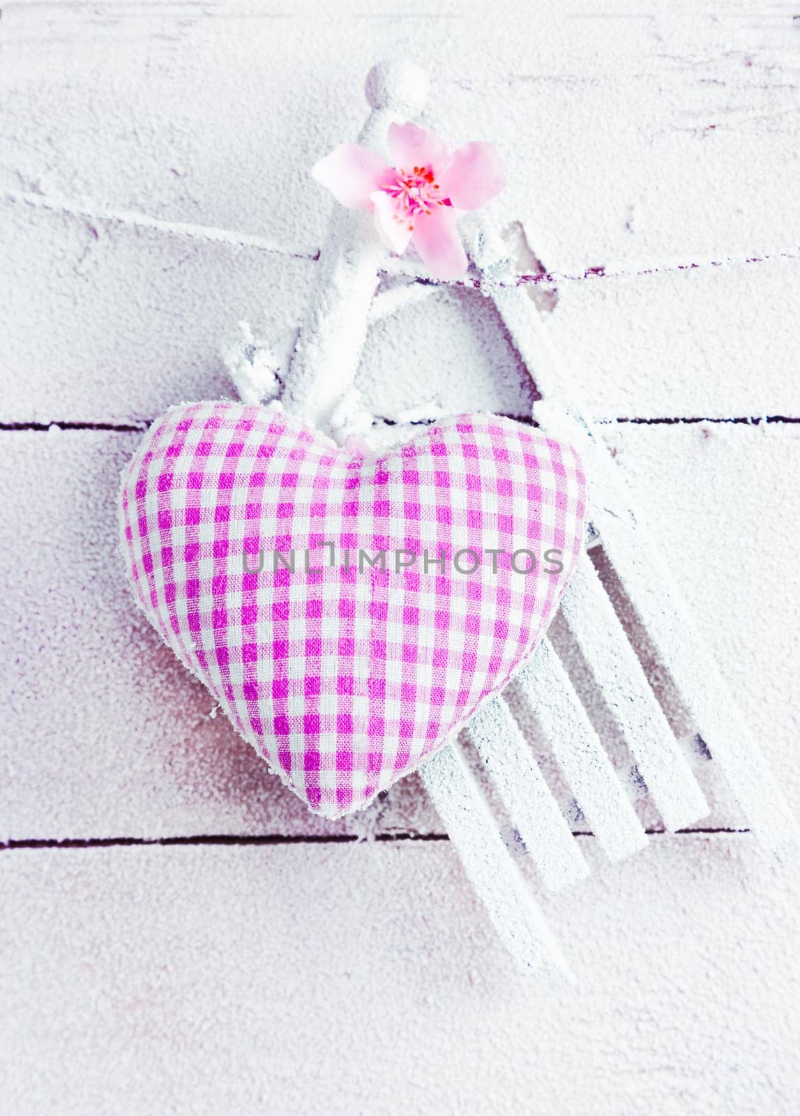 Romantic checked snowy needlework heart for Valentines hanging on snow white boards with copyspace