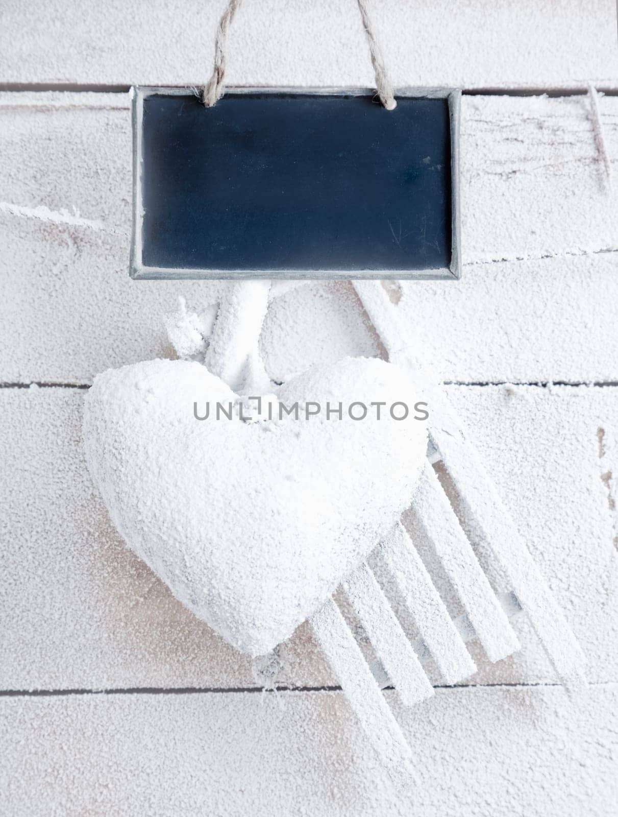 Romantic checked snowy heart for Valentines hanging on snow white boards with tag