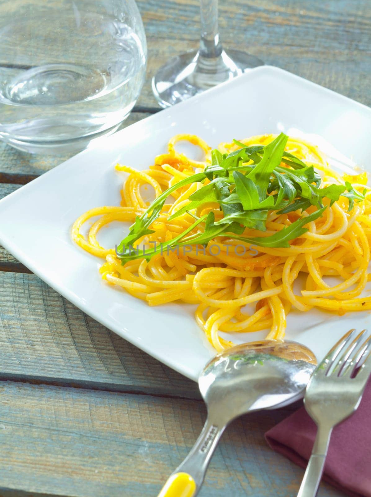 Plate of delicious pasta topped with fresh herbs served ready for dining.