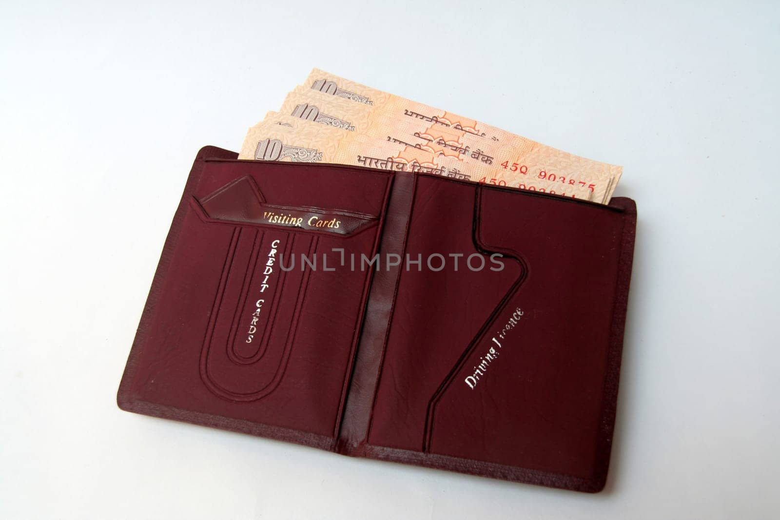Brown wallet containing Indian currency notes isolated on white