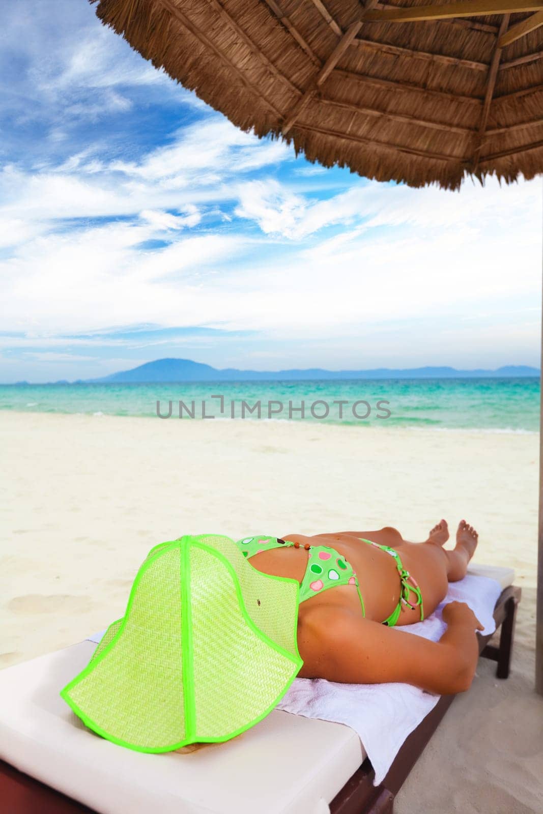 Young woman sunbathing on the chair near the ocean