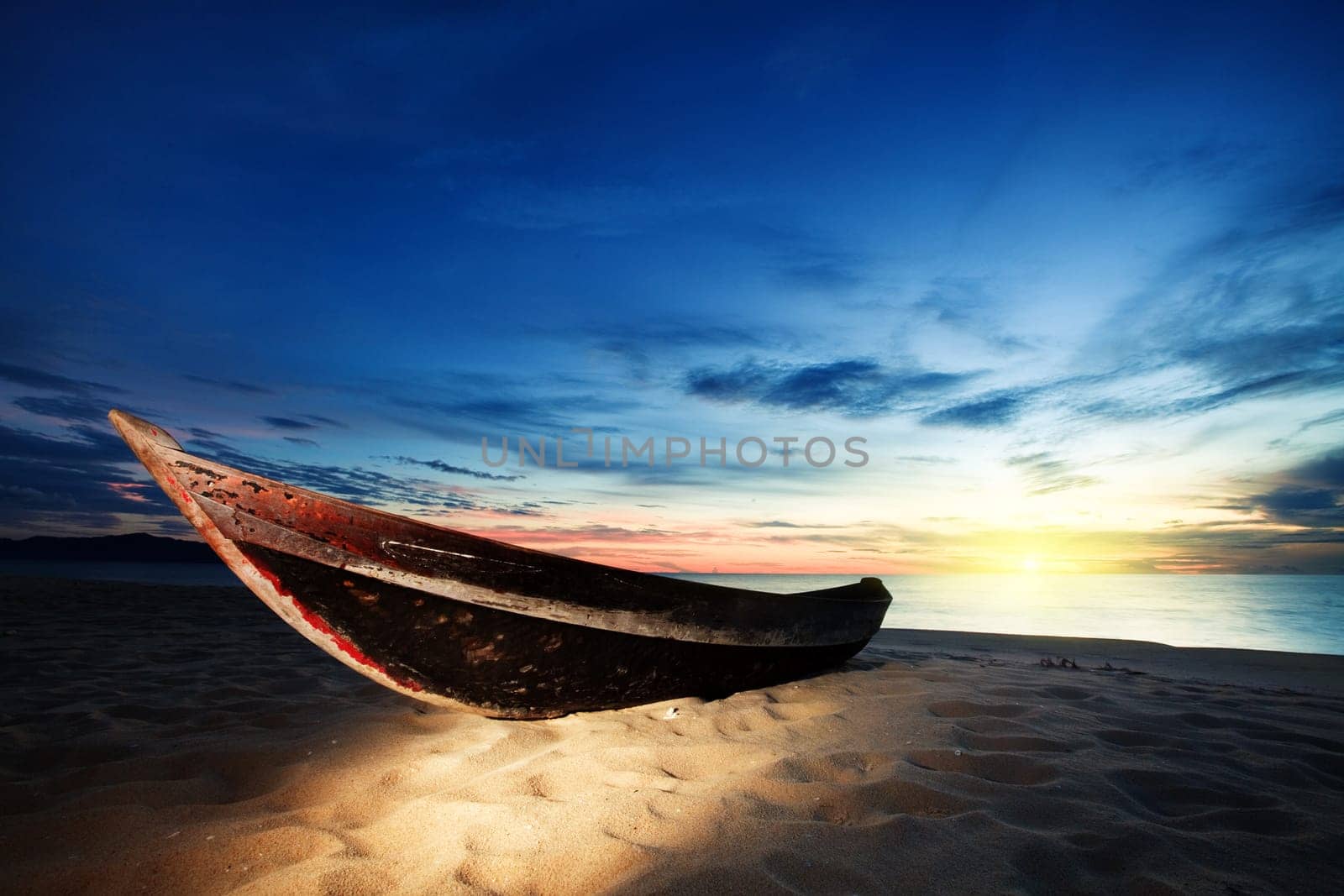 Old fisherman boat at sunrise time on the beach