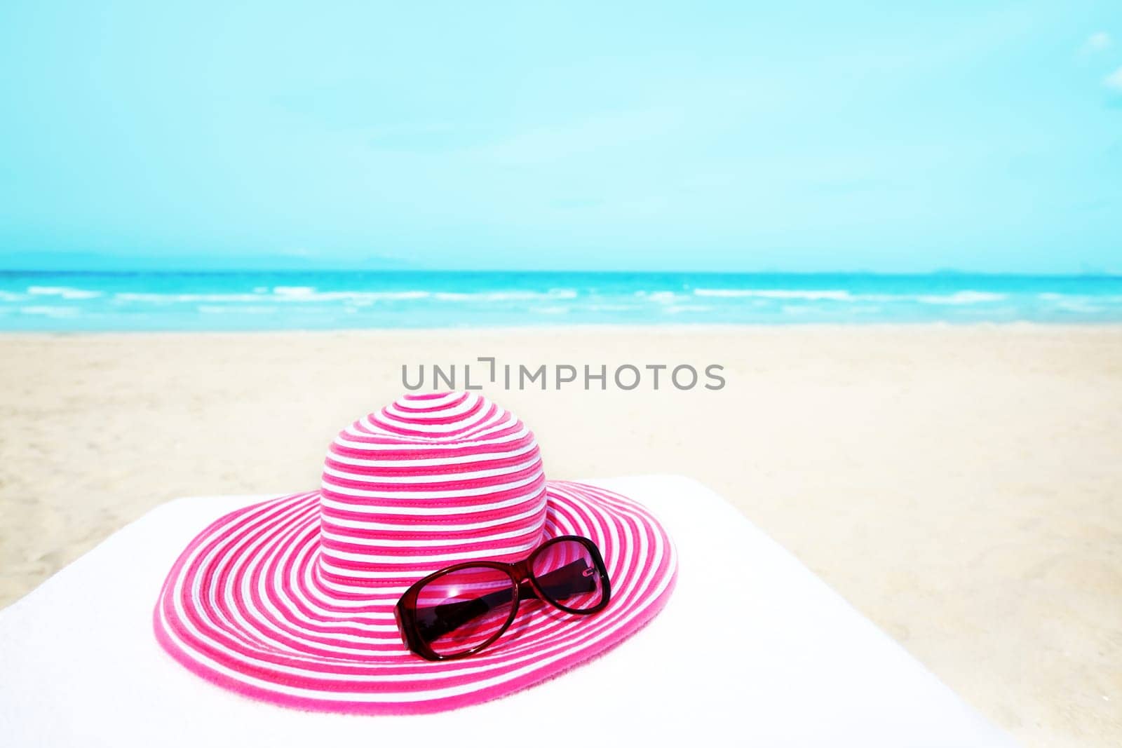 Pink hat and sunglasses near the ocean