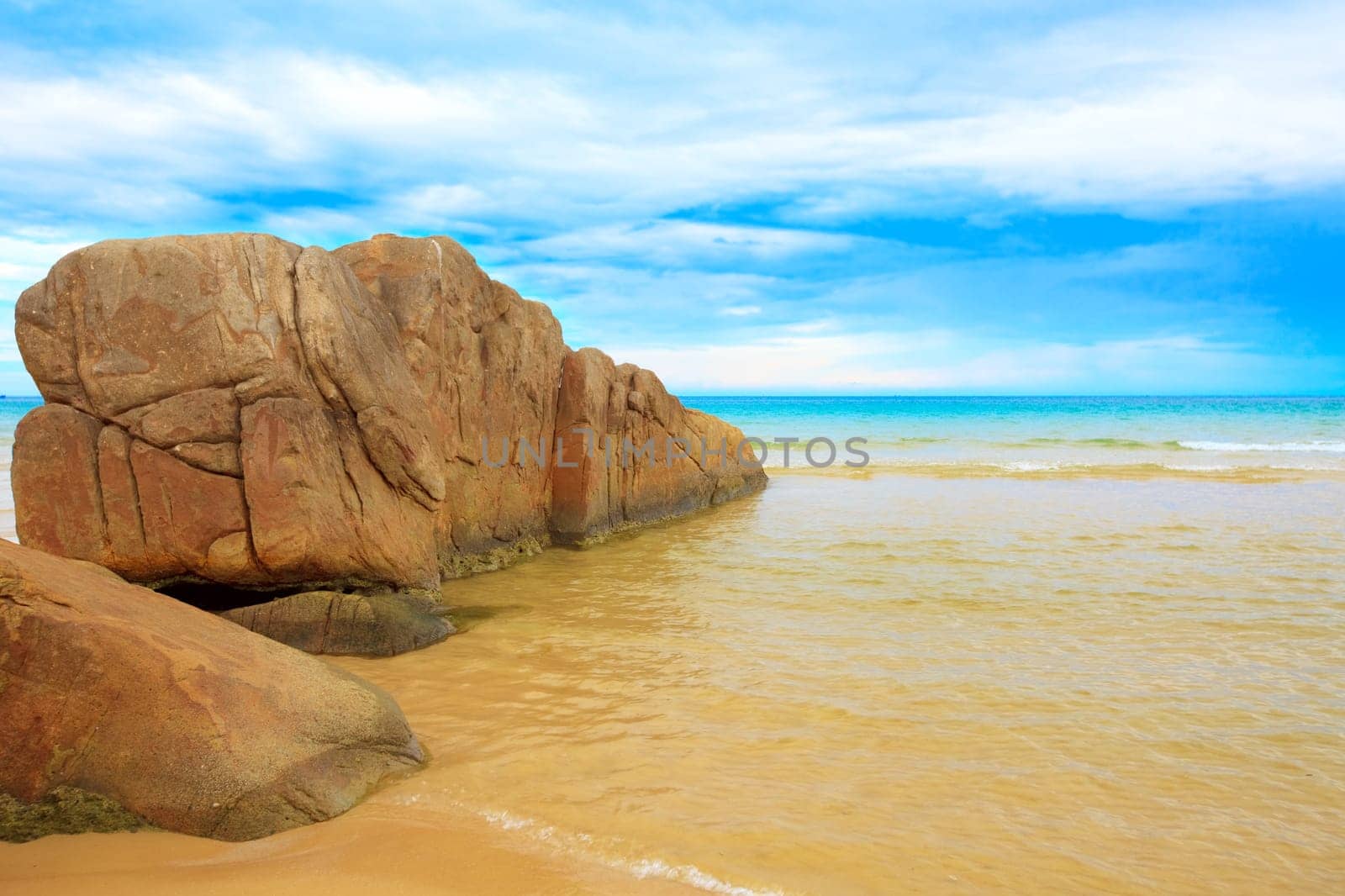 Tropical beach with rock and cloudu sky
