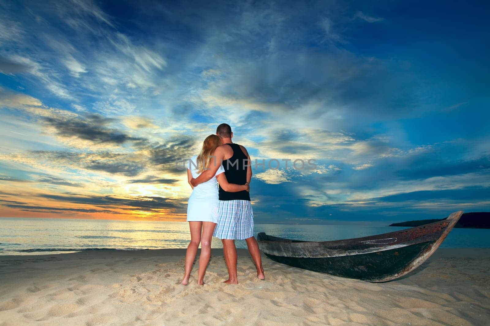 Romantic couple at uninhabited island at sunset time