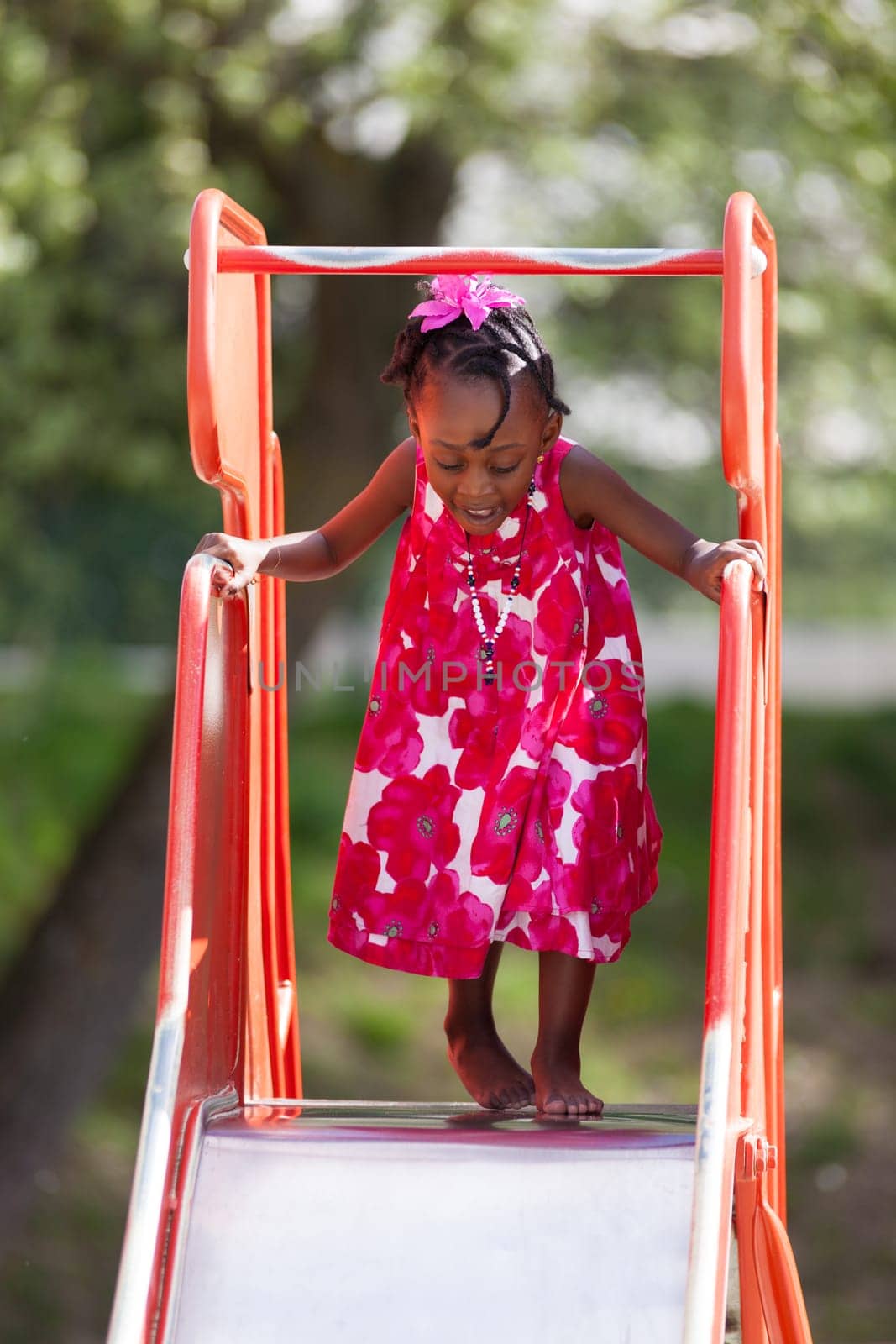 Outdoor Portrait of a cute african american little girl playing at playground