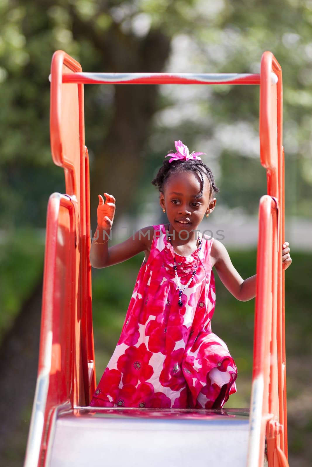 Outdoor Portrait of a cute african american little girl playing at playground