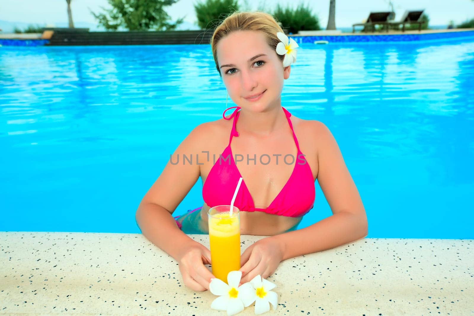 Woman wth moktail relaxing in swimming pool