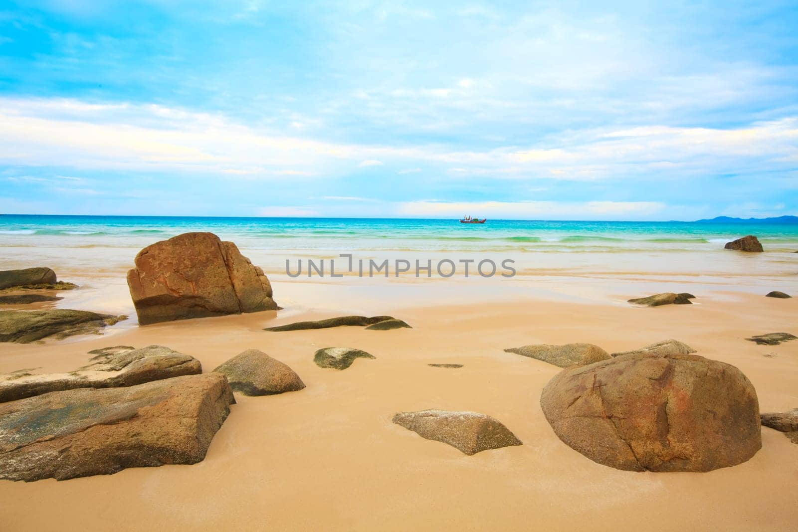 Tropical beach with rock and cloudy sky