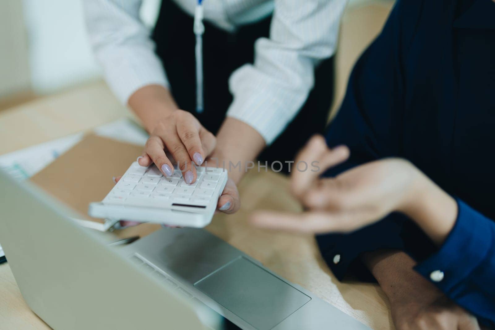 Two business people meeting to talking or discuss marketing work in workplace using paperwork, calculator, computer to work.