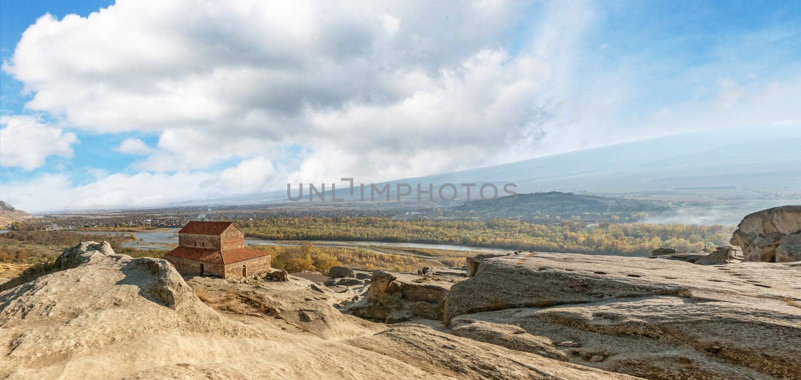 Panoramic view of the rock-hewn town of Uplistsikhe overlooking the distant city and river