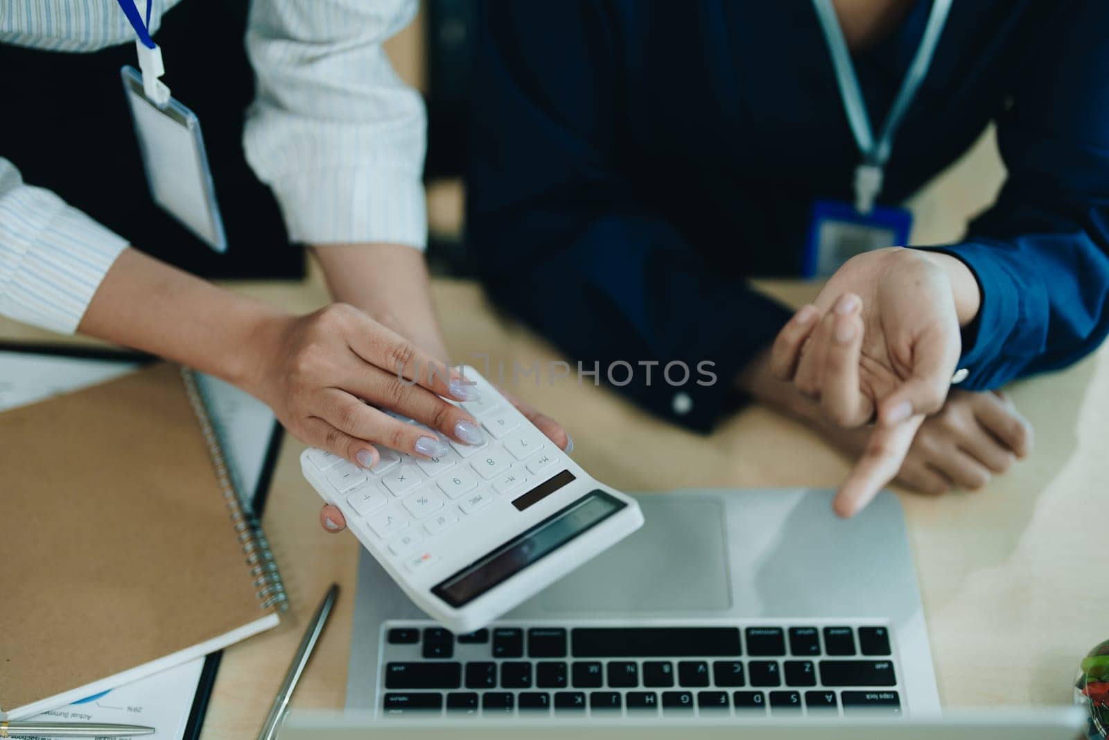 Two business people meeting to talking or discuss marketing work in workplace using paperwork, calculator, computer to work.