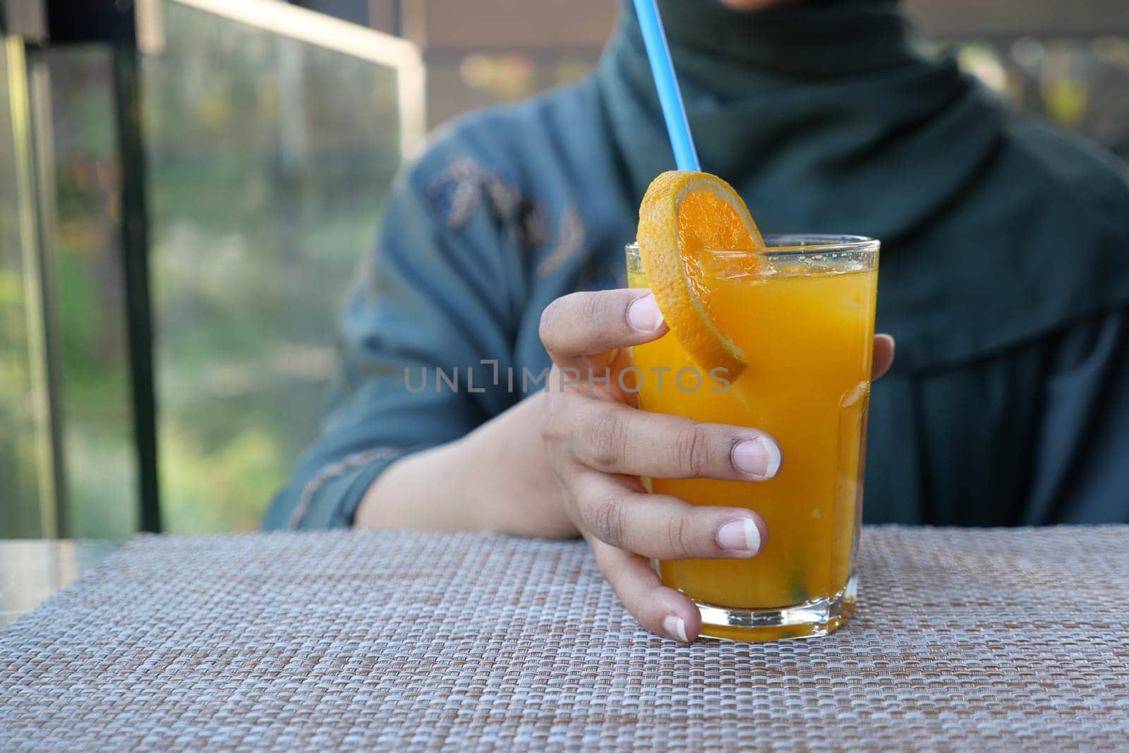 women holding a glass of orange juice outdoor by towfiq007