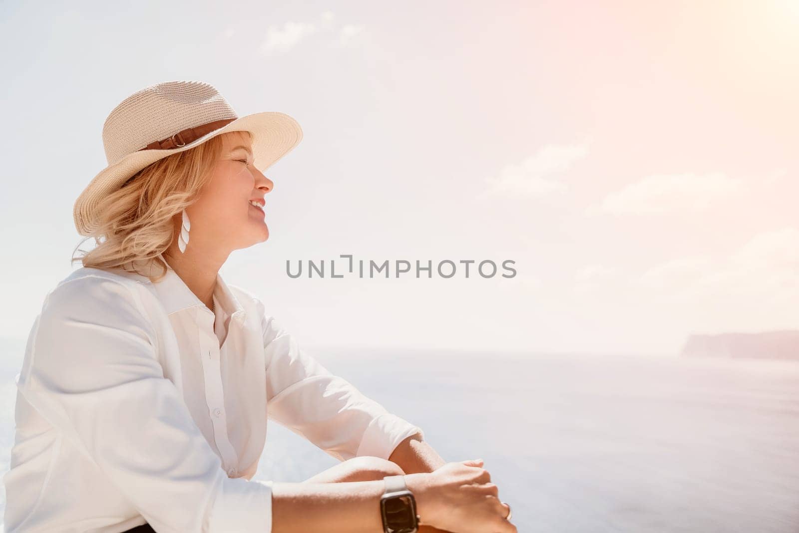 Woman sea laptop. Business woman in yellow hat freelancer with laptop working over blue sea beach. Girl relieves stress from work. Freelance, digital nomad, travel and holidays concept by panophotograph