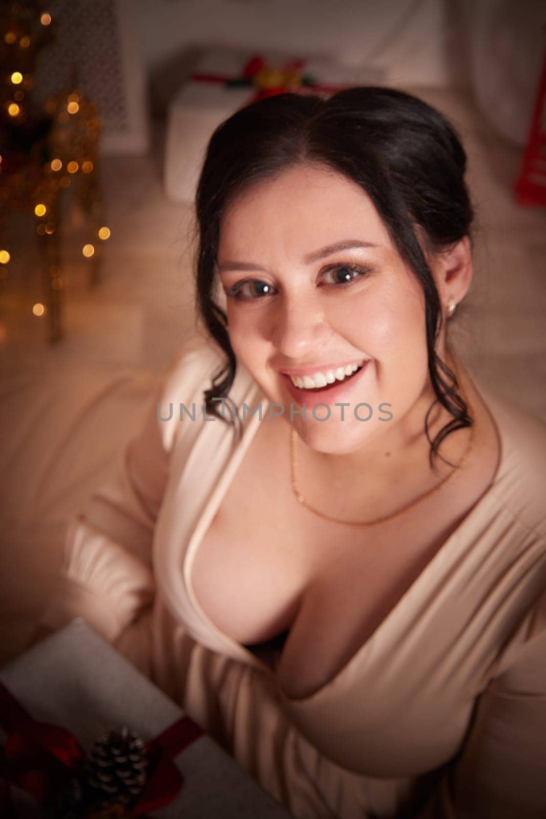 Portrait of Owerweight elegant Woman at Christmas room. Fat plumb pretty girl in a beautiful dress for a holiday. Buxom female model posing alone in New year sudio