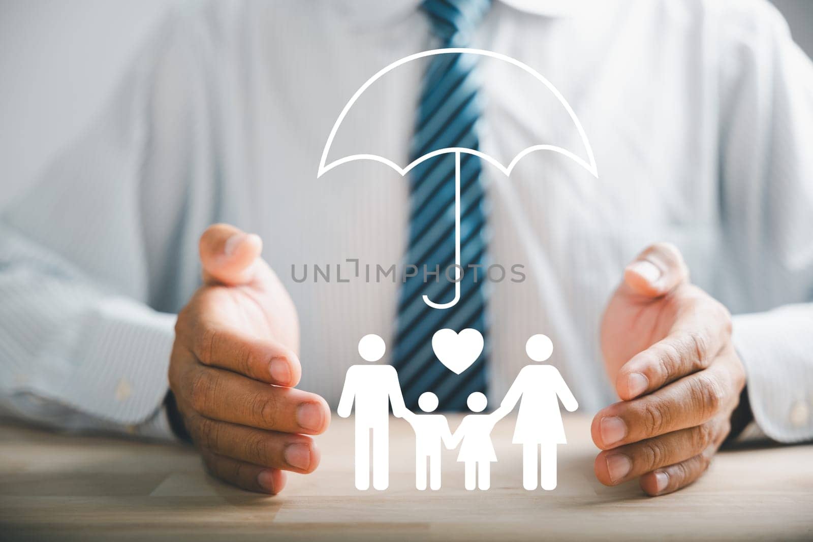 Insurance concepts, a businessman protective gesture beside a silhouette of a young family. Icons for family, life, health, and house insurance. Depicting family life insurance and policy assurance.